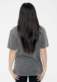 Oversized gray cotton t-shirt with a soft texture, short sleeves, and a loose fit, shown from the back against a plain white background.