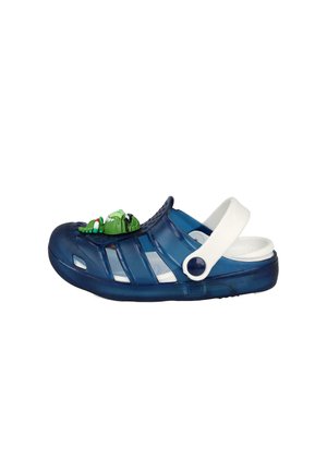 Zueco de plástico azul marino con correa blanca para el talón y una decoración de rana de dibujos animados verde en la parte superior.