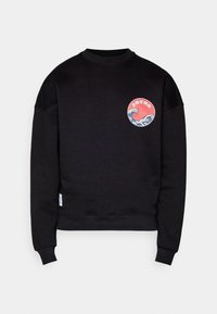 Fekete pulóver kerek, színes grafikával, amely hullámokat és a "JAPAN" feliratot ábrázolja. Bordás környakú és mandzsetta. Puha tapintású.