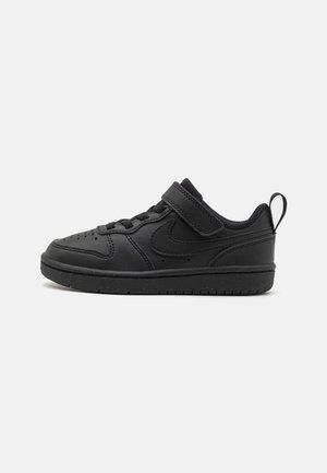 Czarny niski sneaker z paskiem na rzep, detalem sznurowadeł, logo Nike Swoosh po boku, wyściełanym kołnierzem i pętlą z tyłu przy pięcie.
