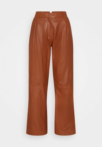 Calças largas em couro castanho com cintura alta, apresentando uma textura suave e pregas subtis à frente e atrás.