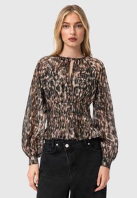 Μπλούζα με λεοπάρ σχέδιο, με άνοιγμα στη λαιμόκοψη, ελαστική μέση και φουσκωτά μανίκια. Τα χρώματα περιλαμβάνουν καφέ, μαύρο και κρεμ. Συνδυάζεται με μαύρο τζιν.