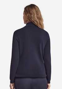 Navyblauer Rollkragenpullover mit langen Ärmeln, feiner Strickstruktur, geripptem Kragen und Saum sowie lockerer Passform, von hinten gezeigt.
