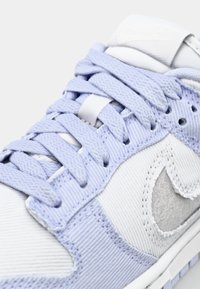 Ljuslila Nike-sneakers med vita accenter, med strukturerat tyg, tjocka snören och broderad logotypdetalj på tungan.