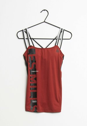 Haut de sport rouge sans manches avec texte vertical noir « LES MILLS » et bretelles doubles blanc-noir sur cintre noir sur fond blanc.