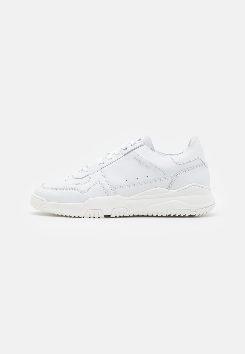 Vita lädersneakers med texturerade detaljer, snörning och en gummisula med zickzackmönster för grepp.