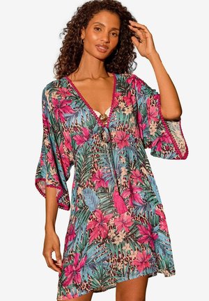 Kaftan imprimat cu un model vibrant de flori și leopard, decolteu în V, mâneci largi și detalii cu ciucuri de-a lungul tivului și decolteului.