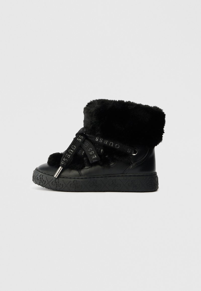 Bottine noire avec un épais revers en fourrure, lacets larges estampillés "GUESS," et semelle à motifs sur fond uni.