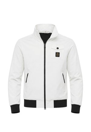 Giacca bianca con zip, collo alto, zip nera, polsini e orlo neri, tasca sul petto con pattina e toppa nera, tasche laterali con zip.