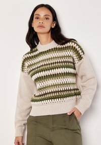 Sweter dzianinowy w zielono-beżowy paskowany wzór z teksturowanej przędzy. Żebrowany dekolt i mankiety, z luźnymi rękawami i dołem.