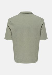 Kurzärmeliges Poloshirt aus weichem, strukturiertem, hellgrünem Stoff mit flachem Kragen und lockerer Passform, ausgestattet mit einem geraden Saum.