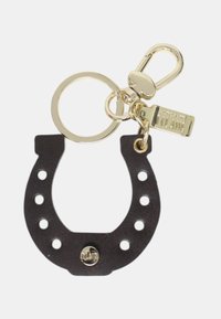 Czarny skórzany brelok w kształcie podkowy z złotym pierścieniem, zapięciem i małą prostokątną metalową zawieszką wygrawerowaną napisem "1a CLASSE".