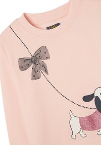 Sweatshirt rose avec un graphique de nœud à pois noirs et un chien blanc avec des détails en paillettes roses. Texture de tissu lisse.