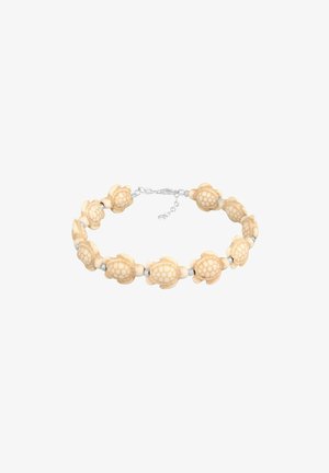 Bracelet avec des perles beige en forme de tortue liées par de petits intercalaires argentés et un fermoir réglable en argent.