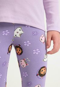 Fioletowe legginsy z wzorami postaci z kreskówek, kwiatów i uroczych zwierząt. Miękki materiał, dopasowany krój i subtelny ściągacz w pasie.