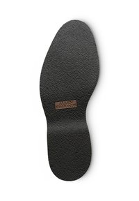 Semelle intérieure en caoutchouc noir avec surface texturée, présentant une étiquette en relief marron avec "ALLEN EDMONDS" sur le dessus.