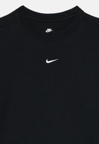 Černé bavlněné tričko s kulatým výstřihem a krátkými rukávy, s bílým logem Nike uprostřed hrudníku. Texturovaná tkanina, klasický střih.