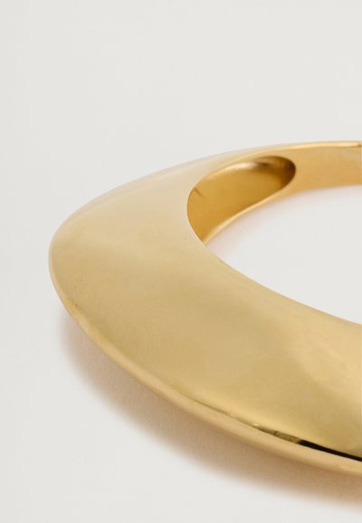 Kuldmetallist choker-kaelakee sujuva, kaardus disainiga ja poleeritud viimistlusega, millel on ümmargune lõikeauk mugavaks kandmiseks.