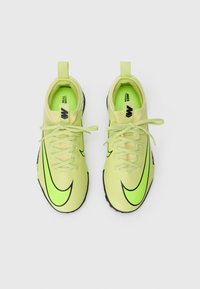 Svijetlozelene atletske tenisice s teksturiranim gornjim dijelom, crnim potplatom i kontrastnim crnim Nike znakom. Imaju šest rupica za vezivanje i ravne vezice.