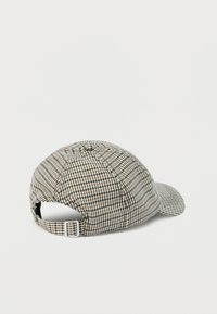 Καπέλο μπέιζμπολ με καρό ύφασμα, ρυθμιζόμενο λουράκι και μεταλλική αγκράφα, εμφανιζόμενο από πίσω σε λευκό φόντο.