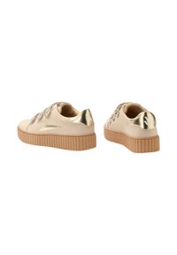 Sneakers platform beige con accenti metallici dorati, lacci testurizzati e suola rigata. Punta rotonda e design low-top.