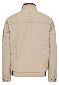 Beige jacket with a stand-up collar. Features a zipper closure, side pockets, and ribbed accents on the collar and hem. Smooth texture.