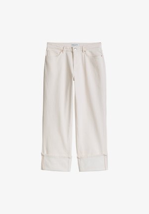 Jeansy o prostych nogawkach w kolorze ecru, z podwiniętymi mankietami, frontowym guzikiem oraz kieszeniami, prezentowane na białym tle.