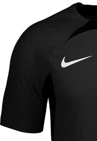 Zwart sportshirt met korte mouwen, voorzien van een gestructureerd patroon en een wit Nike-logo aan de linkerkant van de borst.