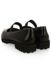 Scarpe in pelle nera con finitura lucida, dotate di punta arrotondata, fasce elastiche e una suola nera spessa e strutturata per una maggiore aderenza.