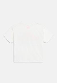 Λευκό T-shirt με κοντά μανίκια, εμφανιζόμενο από πίσω σε λευκό φόντο, απλό με ένα διακριτικό ροζ λογότυπο κοντά στη λαιμόκοψη.