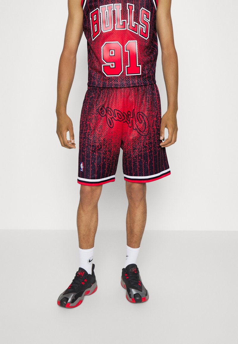 Maillot de basket-ball rouge et noir avec des rayures, arborant les lettres "BULLS" et "91", associé à des baskets noires et des chaussettes blanches.