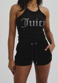 Svart halternecktopp med silverfärgade rhinestone-ordet "Juicy" och matchande svarta shorts med dragsko i midjan och sidofickor. Mjukt tyg.