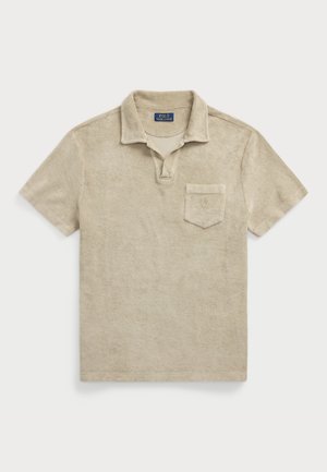 Polo beige a maniche corte con colletto, taschino sul petto e tessuto morbido in spugna, disteso su uno sfondo chiaro.