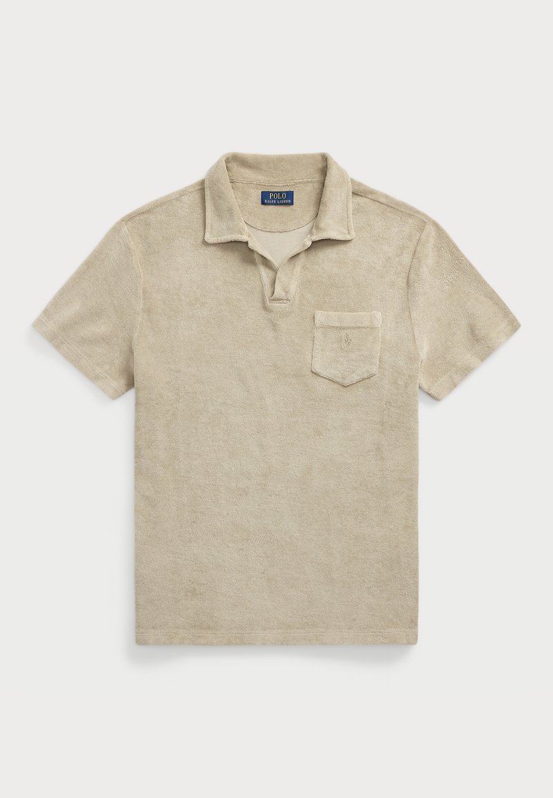 Polo beige à manches courtes avec col, poche poitrine et texture douce en tissu éponge, posé à plat sur un fond clair.