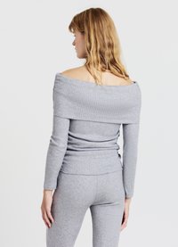 Graues, schulterfreies, rippenstrick-Oberteil mit langen Ärmeln, das eine taillierte Silhouette und eine strukturierte Stoffoberfläche zeigt; passt zu passenden, gerippten Hosen.