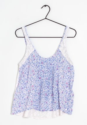 Top senza maniche floreale in tessuto bianco e blu, caratterizzato da un design arricciato con piccoli fiori rosa e dettagli in pizzo sui lati.
