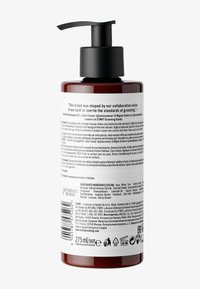Braune zylindrische Flasche mit schwarzem Pumpkopf, auf der Rückseite mit weißen Texten, die Produktinformationen enthalten. Enthält 275 ml des Produkts.
