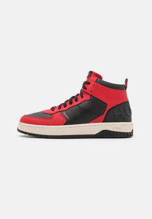Baskets montantes en cuir rouge et noir avec perforations, lacets noirs, semelle beige et marquage en relief "HUGO" au talon et sur le côté.