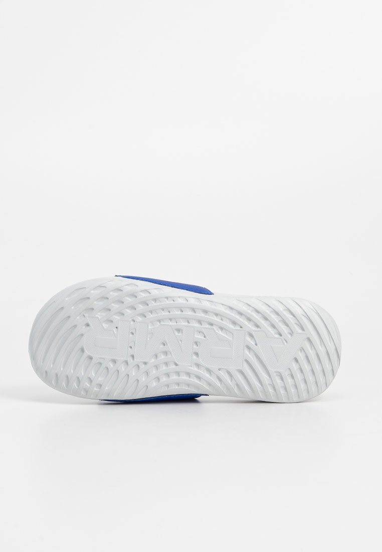 Suela de zapatilla blanca con un patrón de banda texturizado y el logo elevado "APAVI", vista desde abajo sobre un fondo blanco liso.