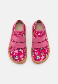 Scarpe di tela rosa con un motivo di personaggi dei cartoni animati, dotate di due cinturini in Velcro e una suola in gomma marrone chiaro.