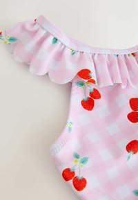Pink checkered swimsuit with ruffled neckline, featuring vibrant red strawberries and light blue flowers. Smooth, stretchy fabric texture.