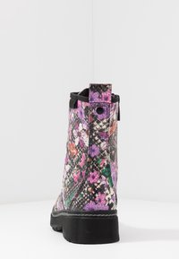 Bottines noires avec un motif texturé en serpent, mettant en valeur des accents floraux colorés en rose, violet et vert, et une semelle en caoutchouc.