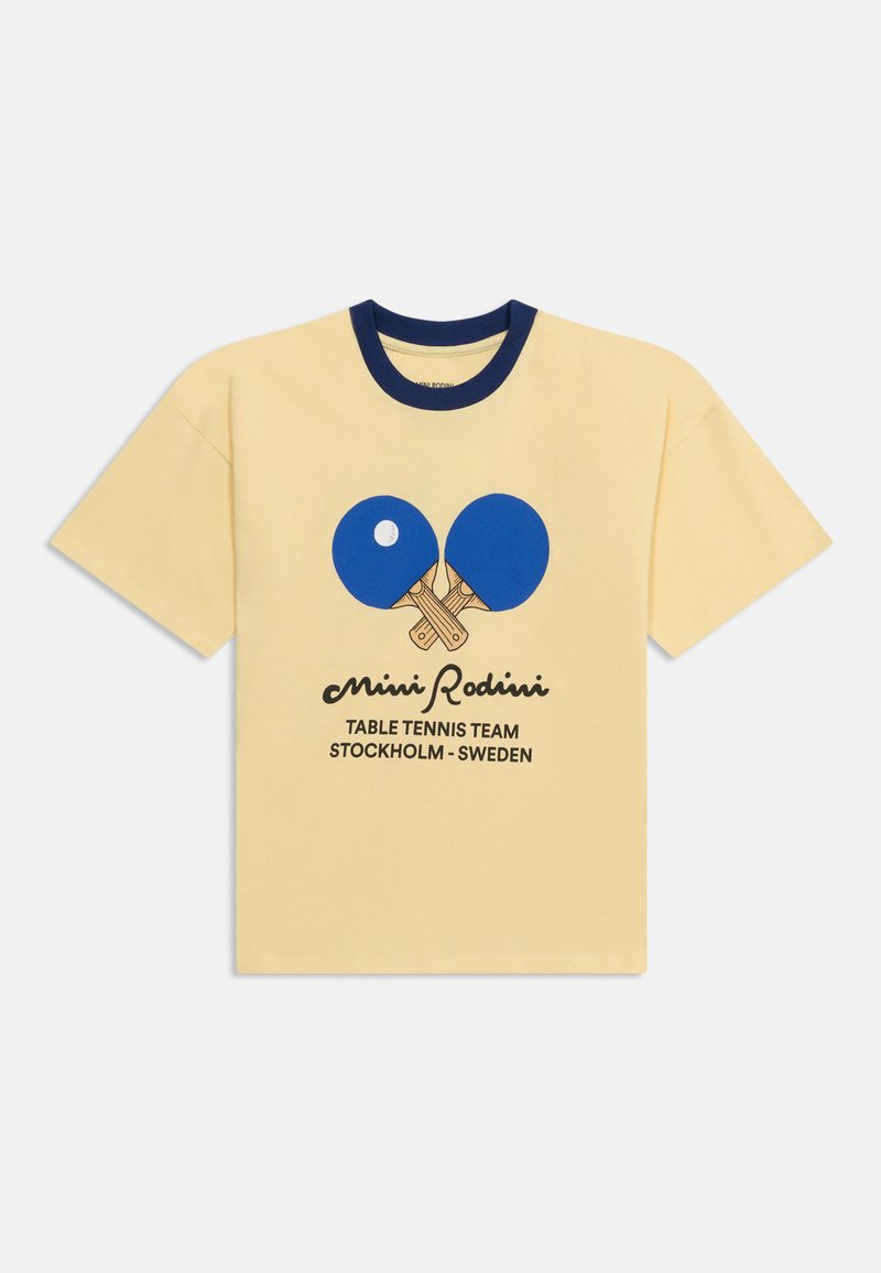 Κίτρινο κοντομάνικο T-shirt με σκούρο μπλε γιακά, μπλε σταυρωμένα ρακέτες επιτραπέζιας αντισφαίρισης, λευκή μπάλα και κείμενο "Mini Rodini Table Tennis Team Stockholm - Sweden."