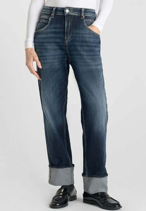 Jeans en denim bleu foncé avec une coupe droite, des ourlets retroussés et cinq poches. Caractéristiques de couture contrastée et d'une fermeture à bouton classique.