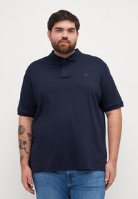 Polo in blu navy realizzato in cotone, con colletto classico, patta con tre bottoni e piccolo logo ricamato sul petto.