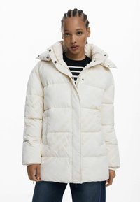 Puffige weiße Jacke mit hohem Kragen, Druckknopfverschluss und subtiler Prägung. Sie verfügt über einen strukturierten Stoff und ein gesteppte Design.