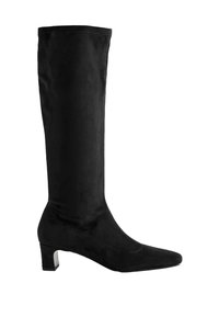 Botte noire montante jusqu'au genou en matériau doux en daim, présentant un bout pointu et un petit talon carré. Détail de couture le long de la tige.