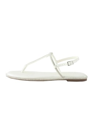 White flat sandal with thin straps, ankle buckle, and rhinestone detailing along the straps and sole edge.