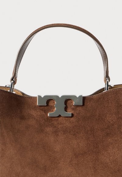 Bolsa de camurça castanha com um fecho metálico prateado e uma alça de couro cosida simples contra um fundo branco.