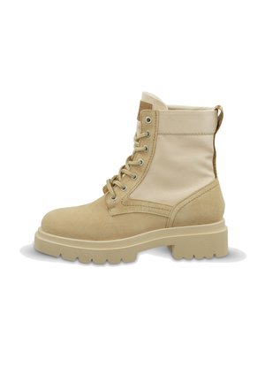 Beige Schnürstiefel mit dicker Gummisohle, Wildleder an Zehen und Ferse, Obermaterial aus Stoff und Zugschlaufe hinten.